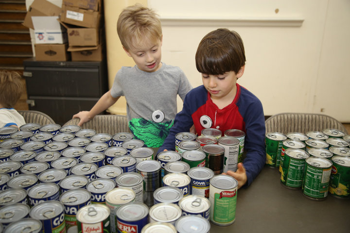 Luca Negron and Ollie Caputo organize cans of vegetables before the Children's Food Pantry opens at Ascension parish in Manhattan Jan. 25.